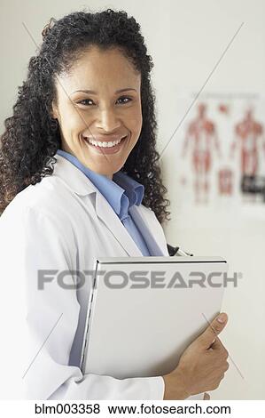 Stock Photo - African female doctor holding medical chart. Fotosearch