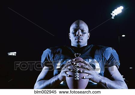 Stock Photography - African football player holding football. Fotosearch