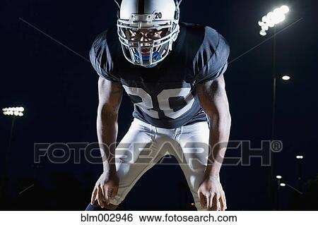 Stock Photograph - African football player in uniform and helmet. Fotosearch