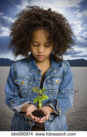 African girl holding seedling in desert View Large Photo Image Picture - African girl holding seedling in desert. Fotosearch