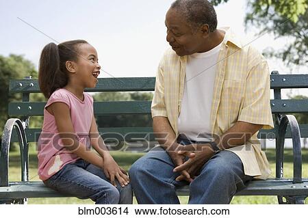 African grandfather and granddaughter sitting on park bench View Large Photo Image Picture - African grandfather and granddaughter sitting on park bench. Fotosearch