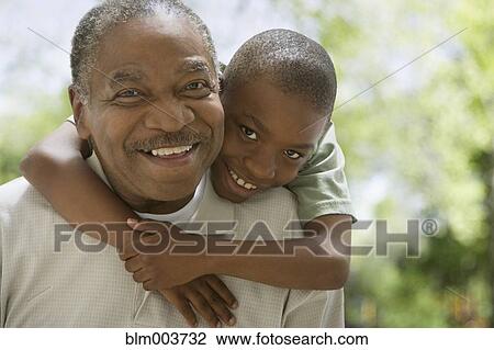 Stock Image - African grandfather and grandson hugging. Fotosearch