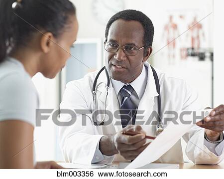 Stock Photograph - African male doctor talking to patient. Fotosearch