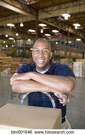 Stock Photograph - African male warehouse worker with hand truck. Fotosearch