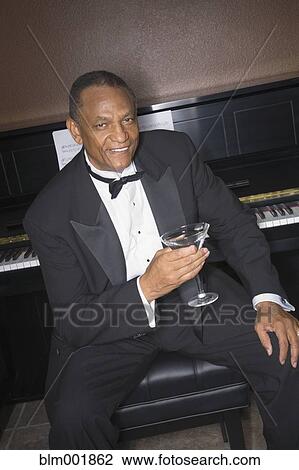 African man drinking cocktail in front of piano View Large Photo Image Stock Image - African man drinking cocktail in front of piano. Fotosearch