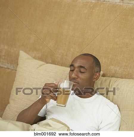 African man drinking coffee in bed View Large Photo Image Stock Image - African man drinking coffee in bed. Fotosearch