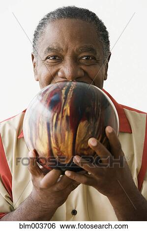 Stock Photograph - African man holding bowling ball. Fotosearch