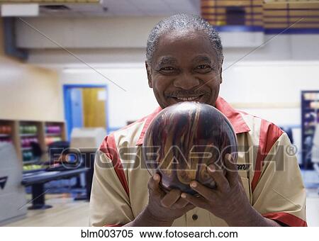 Stock Photography - African man holding bowling ball. Fotosearch