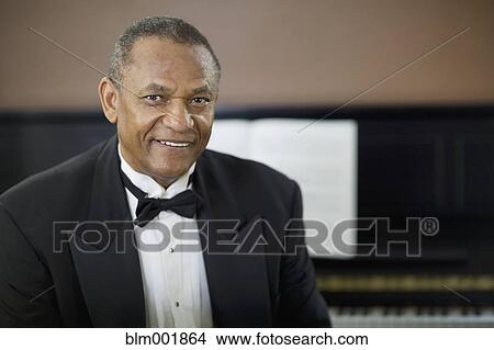 African man in tuxedo sitting in front of piano View Large Photo Image Picture - African man in tuxedo sitting in front of piano. Fotosearch
