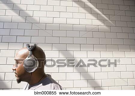 African man listening to headphones in urban setting View Large Photo Image Stock Photography - African man listening to headphones in urban setting. Fotosearch