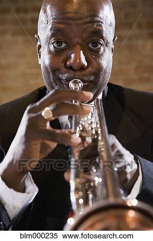Stock Photography - African man performing on trumpet. Fotosearch