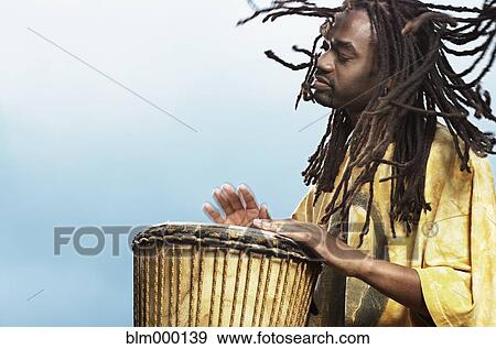 Stock Photo - African man playing drum. Fotosearch
