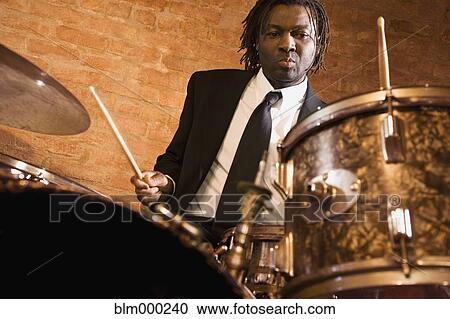 Stock Image - African man playing drums. Fotosearch
