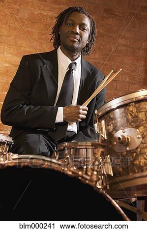 Stock Image - African man playing drums. Fotosearch