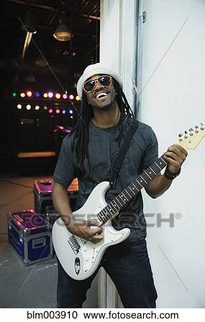African man playing electric guitar backstage View Large Photo Image Stock Image - African man playing electric guitar backstage. Fotosearch