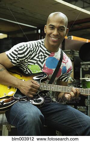 Stock Image - African man playing electric guitar. Fotosearch