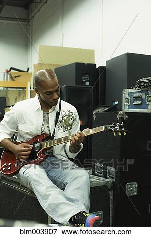 Stock Photo - African man playing electric guitar. Fotosearch