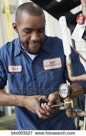 Stock Photo - African man repairing valve. Fotosearch