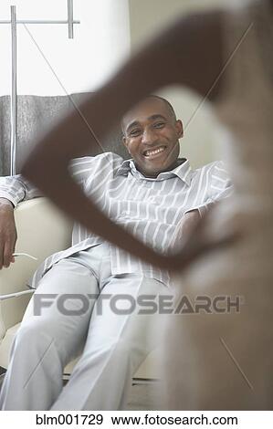 Stock Photo - African man smiling at wife in foreground. Fotosearch