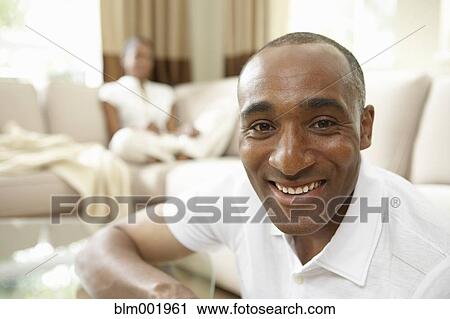 African man smiling with African woman in background View Large Photo Image Stock Image - African man smiling with African woman in background. Fotosearch