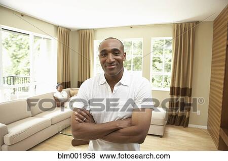 Stock Photo - African man smiling with African woman in background. Fotosearch