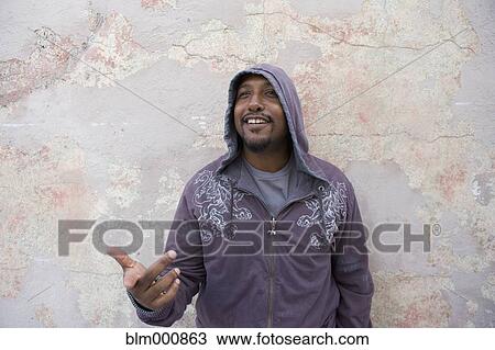 Stock Image - African man standing in front of wall. Fotosearch
