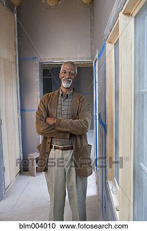 African man standing in hallway of building under construction View Large Photo Image Stock Image - African man standing in hallway of building under construction. Fotosearch