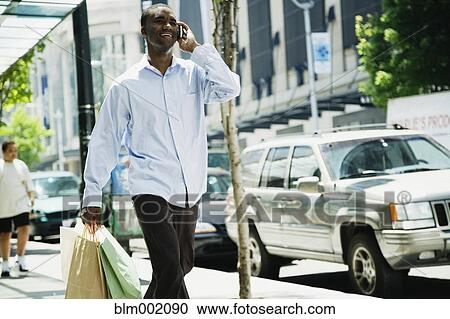 Stock Image - African man talking on cell phone. Fotosearch