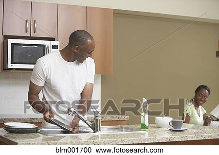African man washing dishes and smiling at wife View Large Photo Image Stock Image - African man washing dishes and smiling at wife. Fotosearch