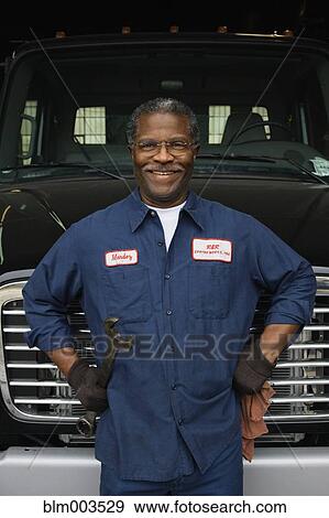 Stock Photo - African mechanic standing in front of truck. Fotosearch
