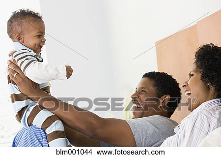 African parents playing with son in bed View Large Photo Image Picture - African parents playing with son in bed. Fotosearch