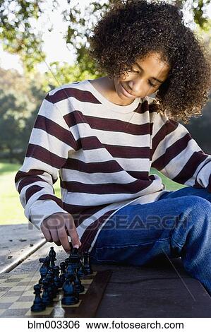 Stock Photograph - African teenager playing chess. Fotosearch