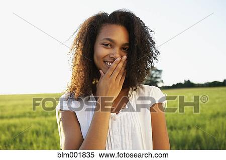 African woman covering mouth with hand while smiling View Large Photo Image Stock Photography - African woman covering mouth with hand while smiling. Fotosearch