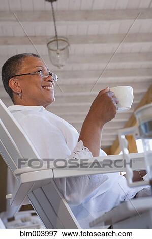 African woman drinking coffee on porch View Large Photo Image Stock Photo - African woman drinking coffee on porch. Fotosearch