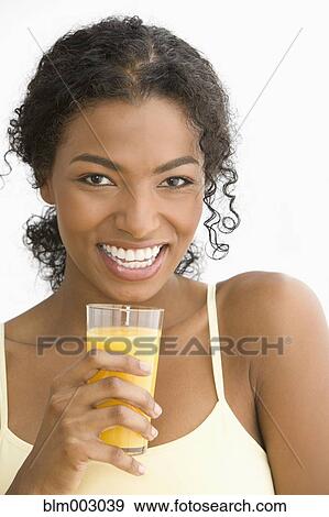 Stock Photo - African woman drinking orange juice. Fotosearch