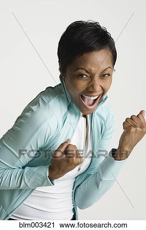 Stock Image - African woman grinning and making fists. Fotosearch