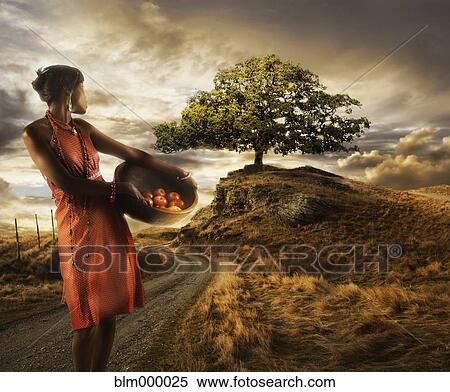 Stock Photography - African woman holding basket of fruit. Fotosearch