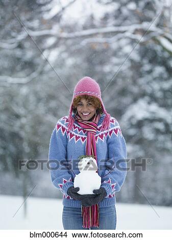 Picture - African woman holding miniature snowman. Fotosearch
