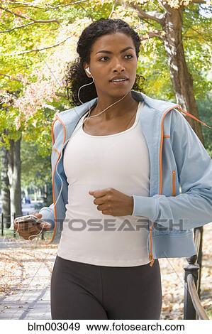 Stock Photo - African woman jogging in urban park. Fotosearch