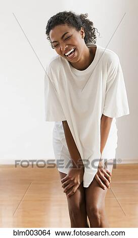 Picture - African woman laughing in large t-shirt. Fotosearch