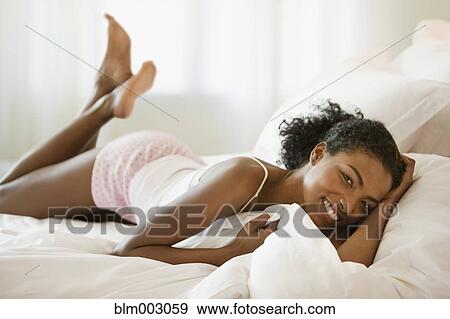 African woman laying on bed View Large Photo Image Stock Photo - African woman laying on bed. Fotosearch