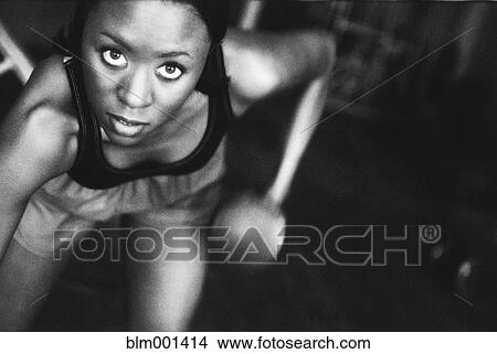 Picture - African woman lifting hand weight. Fotosearch
