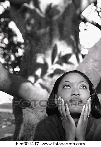 Stock Photo - African woman near tree with head in hands. Fotosearch