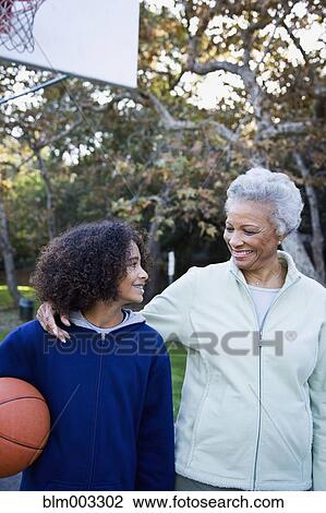 Stock Image - African woman playing basketball with granddaughter. Fotosearch