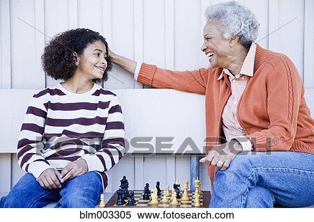 Stock Photography - African woman playing chess with granddaughter. Fotosearch
