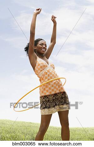 Stock Photography - African woman playing with hula hoop. Fotosearch