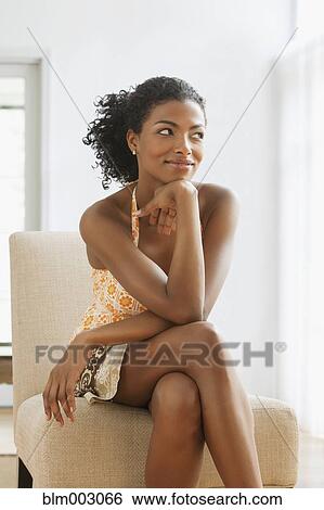 Stock Photograph - African woman sitting in chair. Fotosearch