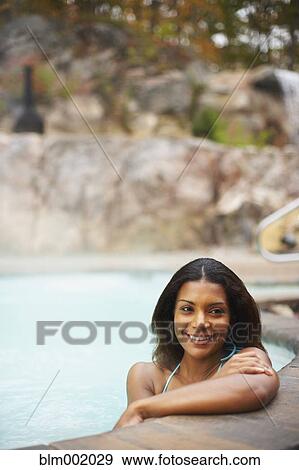 Stock Photo - African woman sitting in hot tub. Fotosearch
