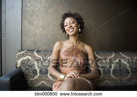 Stock Image - African woman sitting in nightclub. Fotosearch