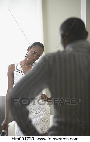 Stock Image - African woman smiling at husband in foreground. Fotosearch